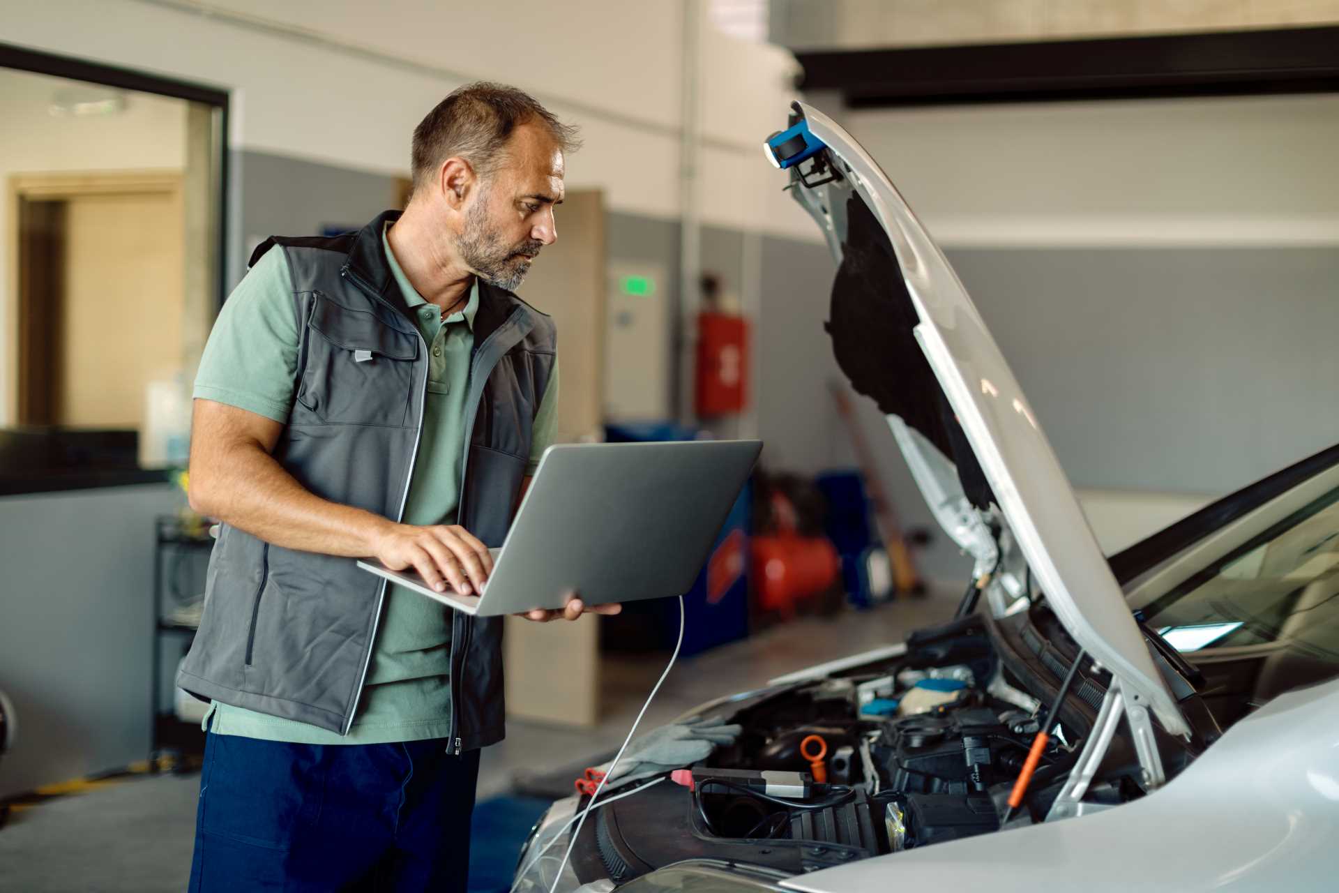 digital vehicle inspections, technician with laptop inspecting car