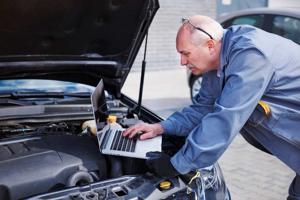 modern garage ideas, mechanic using a computer on car