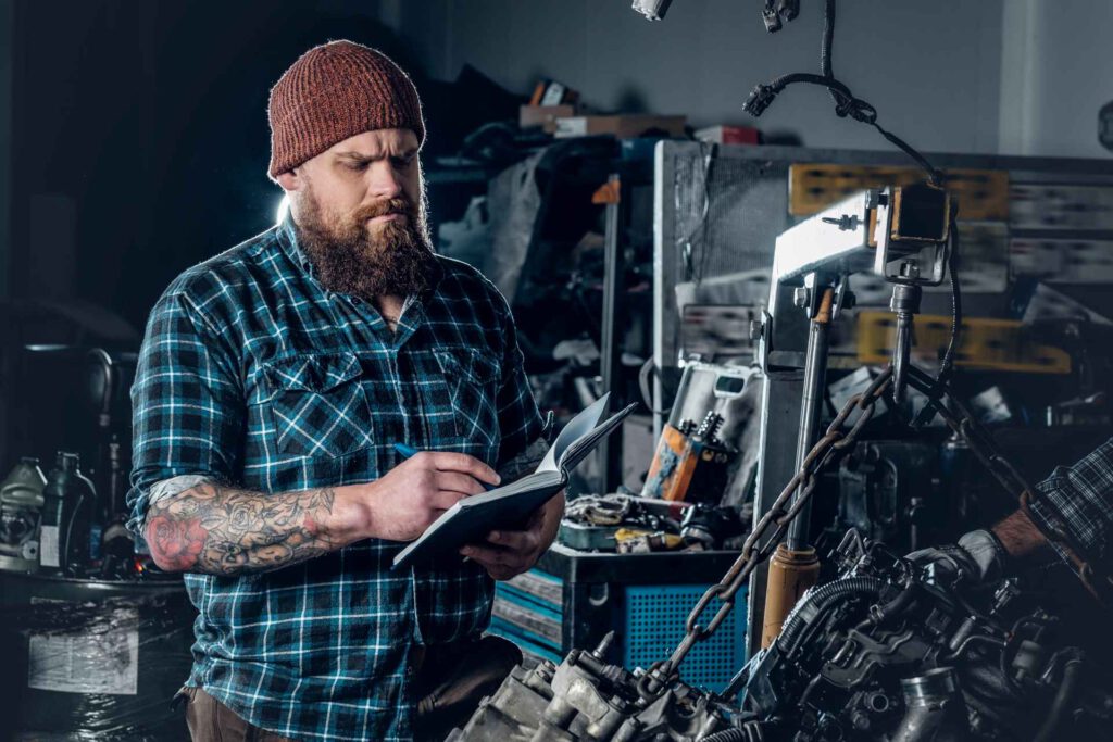 garage office setup, mechanic making a note in his book inside garage