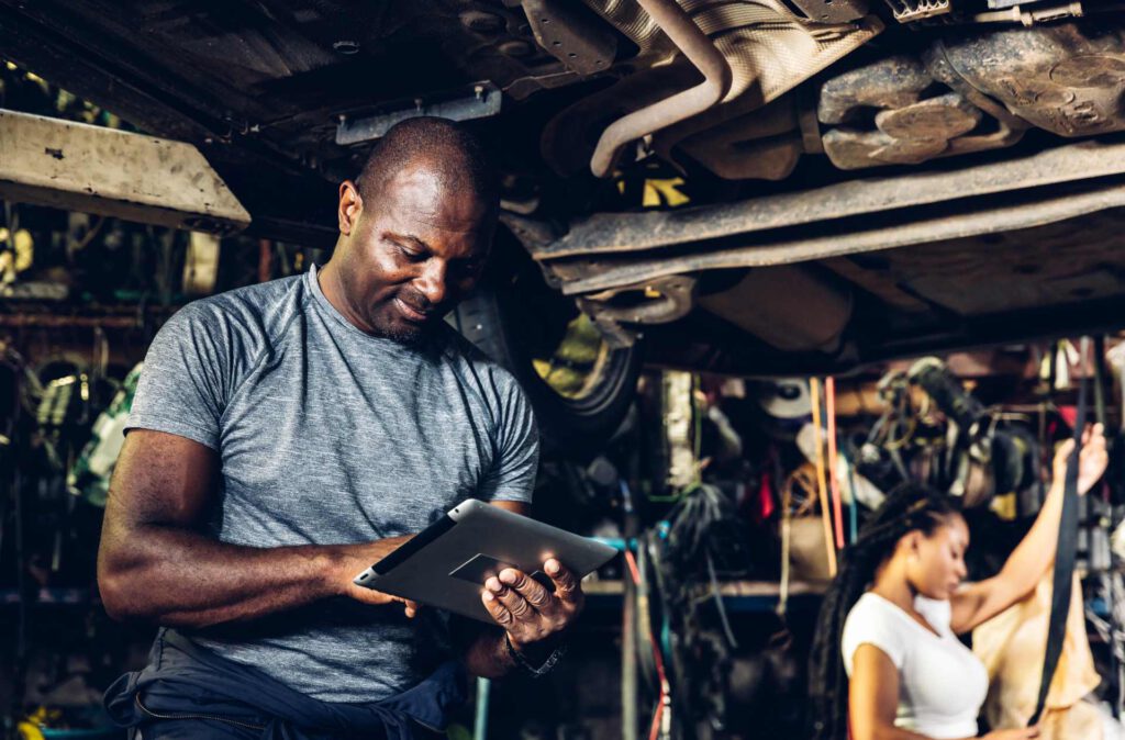 garage services, mechanic using tablet to record data