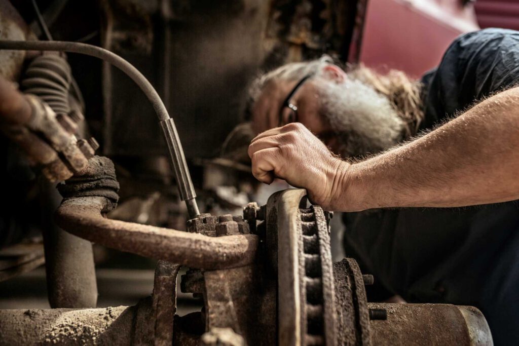 impact garage, old mechanic inspecting and repairing car part