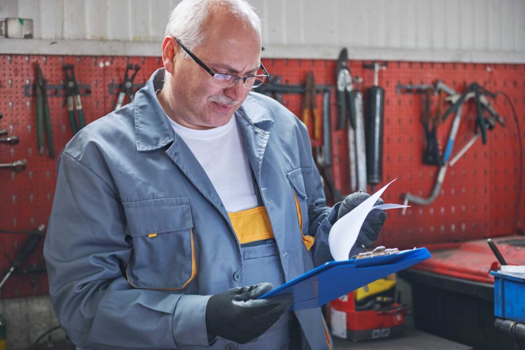 avoid the pitfalls, older mechanic examining his clipboard