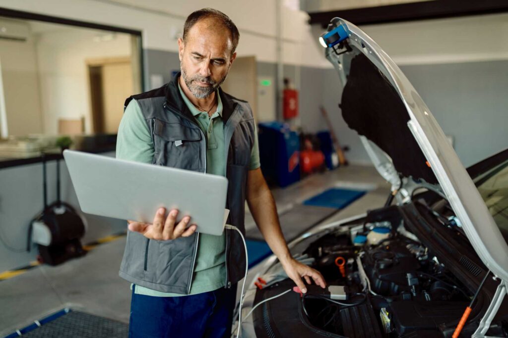 problems with projects, frustrated mechanic using laptop connected to car